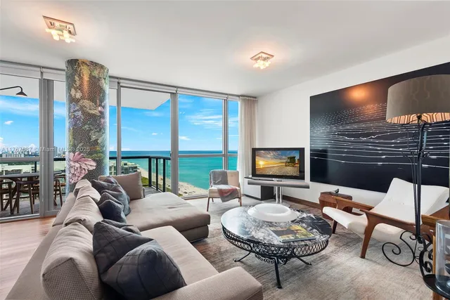 a living room with furniture a large window and a flat screen tv