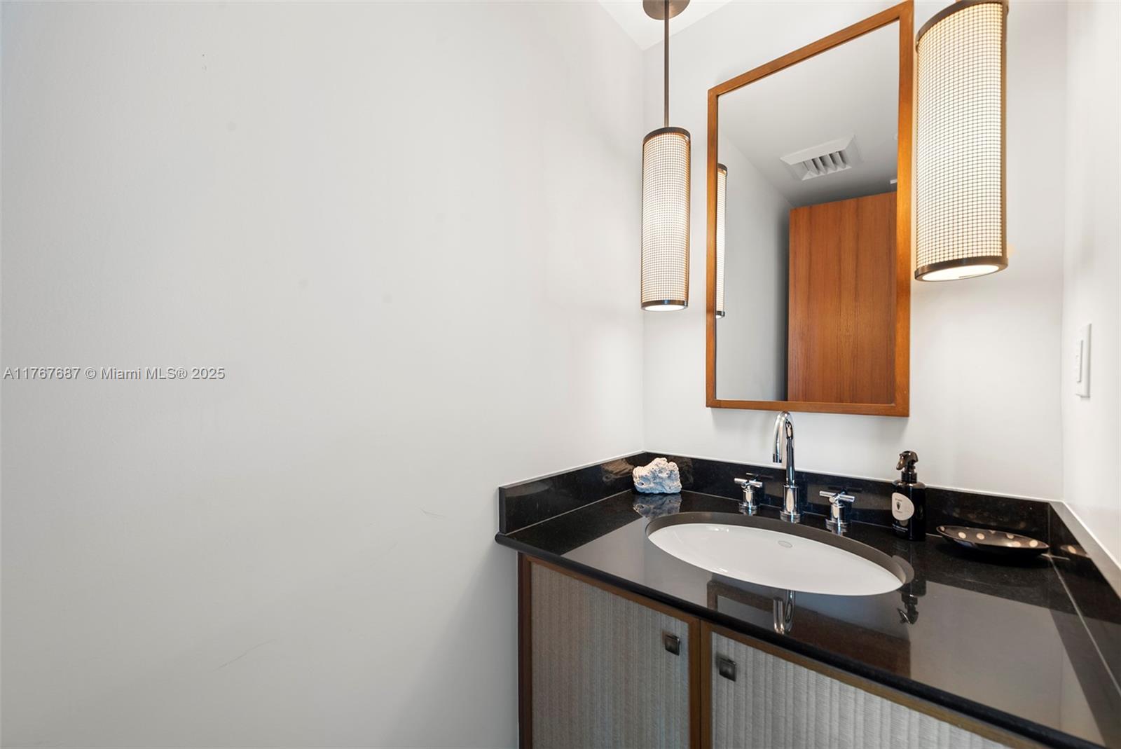 101 20th Street, Unit 3105 Miami Beach, FL 33139 - Photo 31 of 34 a bathroom with a sink and a mirror