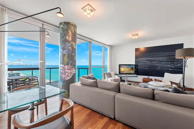 a living room with fireplace furniture and a large window