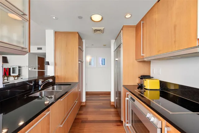 a kitchen with stainless steel appliances a sink stove and cabinets