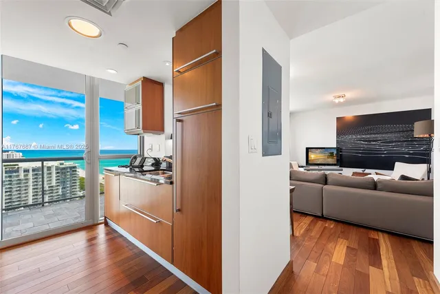 a living room with furniture appliances and wooden floor