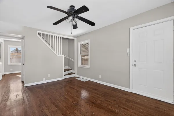 a view of room with wooden floor and ceiling fan