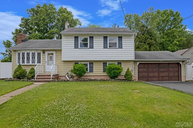 a front view of a house with a garden and yard