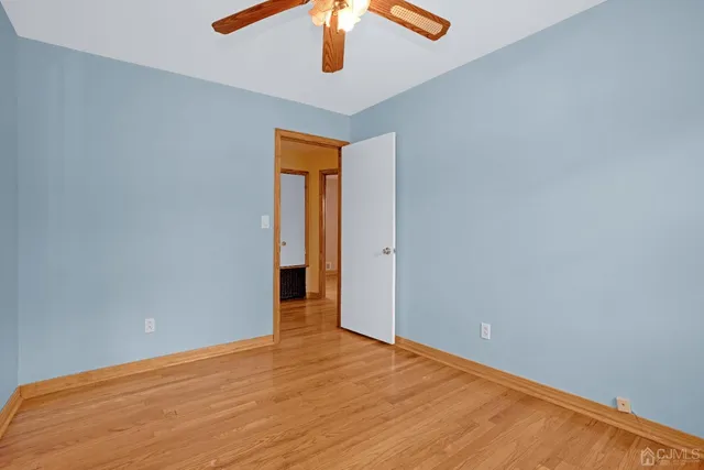 a view of an empty room with a chandelier fan