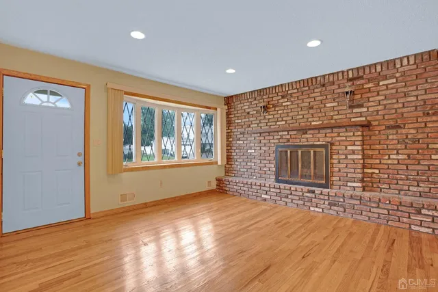 a living room with a wooden floor and a fireplace