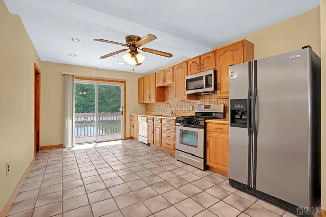 a kitchen with stainless steel appliances granite countertop a refrigerator and a stove top oven