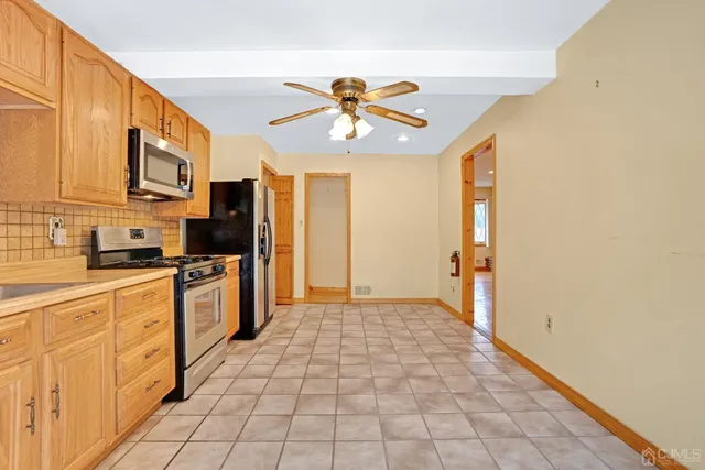 a kitchen with stainless steel appliances granite countertop a refrigerator a stove top oven a sink and dishwasher