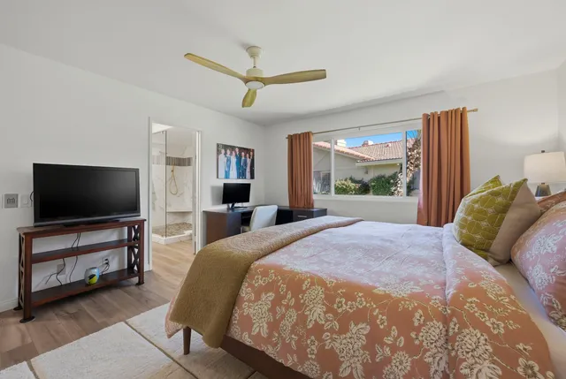 a spacious bedroom with a large bed and a flat screen tv