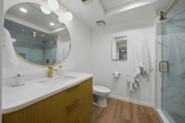 a bathroom with a sink toilet a mirror and shower
