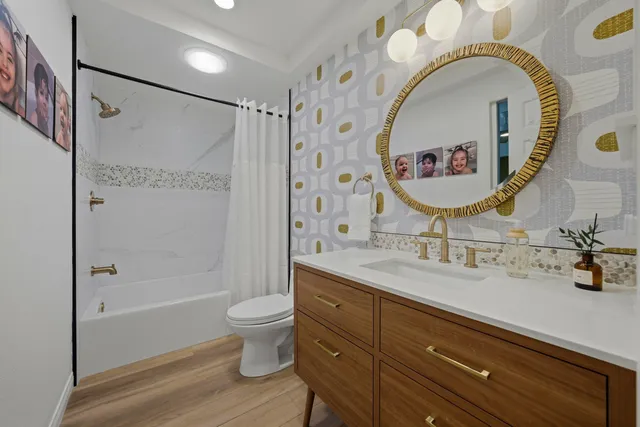 a bathroom with a sink a mirror a toilet and a shower