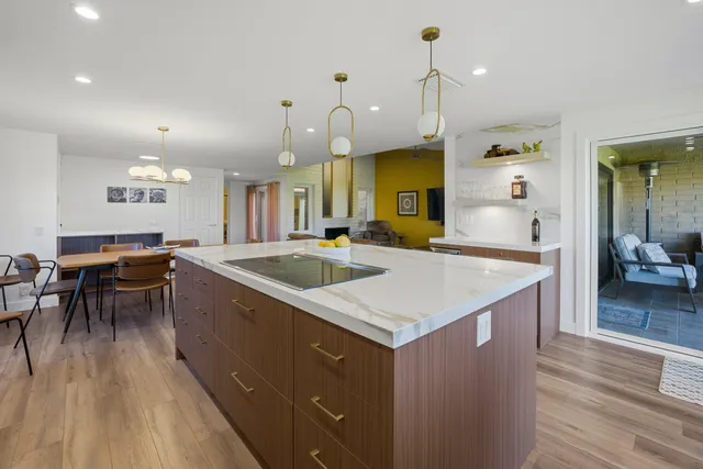a kitchen with a table chairs sink and wooden floor