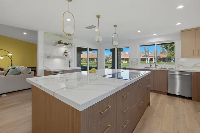 a large kitchen with stainless steel appliances a large counter top