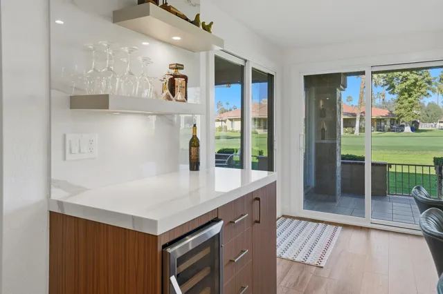 a view of kitchen island with stainless steel appliances granite countertop a refrigerator and a sink