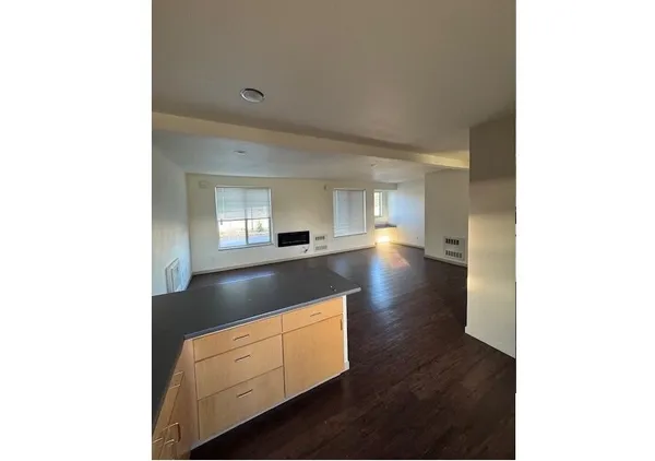 a kitchen with granite countertop white cabinets and wooden floor