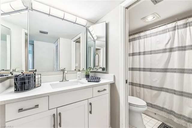 a bathroom with a double vanity sink toilet and shower