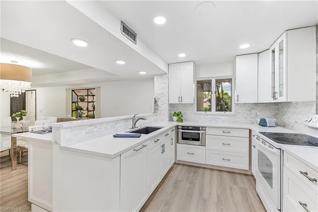 a kitchen with a sink stove cabinets and refrigerator