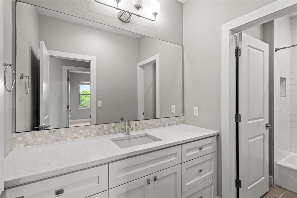 913 Stobaugh Street, Unit B Austin, TX 78757 - Photo 34 of 40 White cabinetry and stone counters define this well-appointed bathroom vanity on the 2nd floor.
