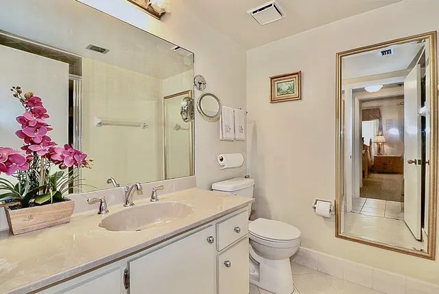 a bathroom with a sink vanity mirror and toilet