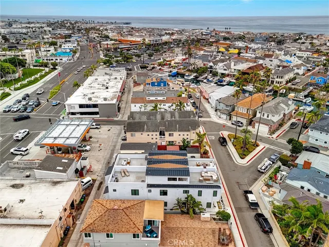 a view of brick house with potted plants and a large tree