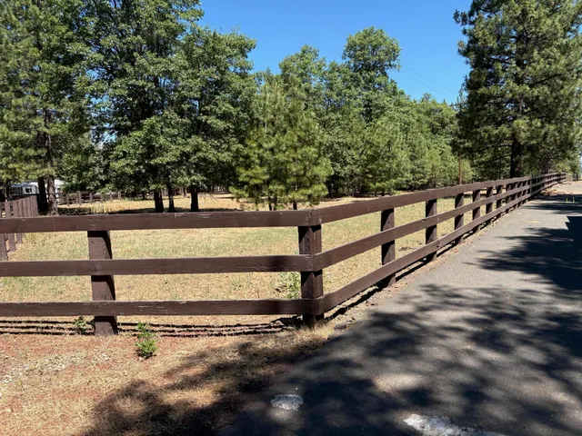 a view of a yard with wooden fence