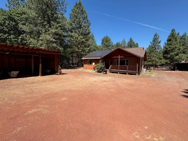 a view of a house with backyard and sitting area