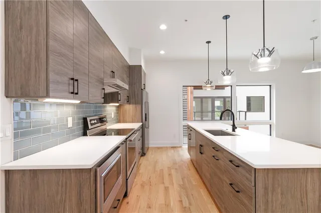a large kitchen with stainless steel appliances kitchen island a large island