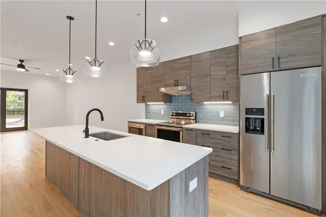 a kitchen with kitchen island a sink stainless steel appliances and kitchen island