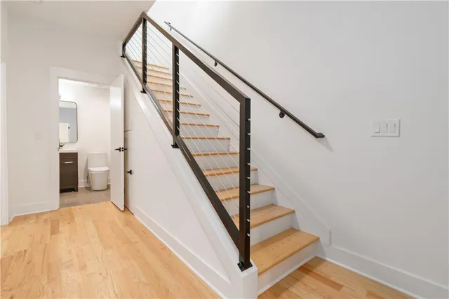 a view of staircase with wooden floor and white walls