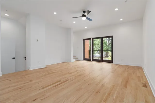 a view of an empty room with a window and a dresser
