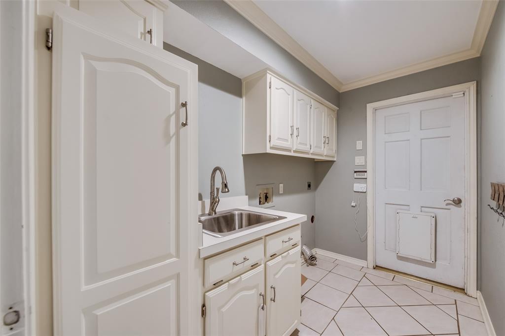 15720 Golden Creek Road Dallas, TX 75248 - Photo 12 of 25 Utility room featuring white cabinetry, a sink with a chrome faucet, and tiled flooring