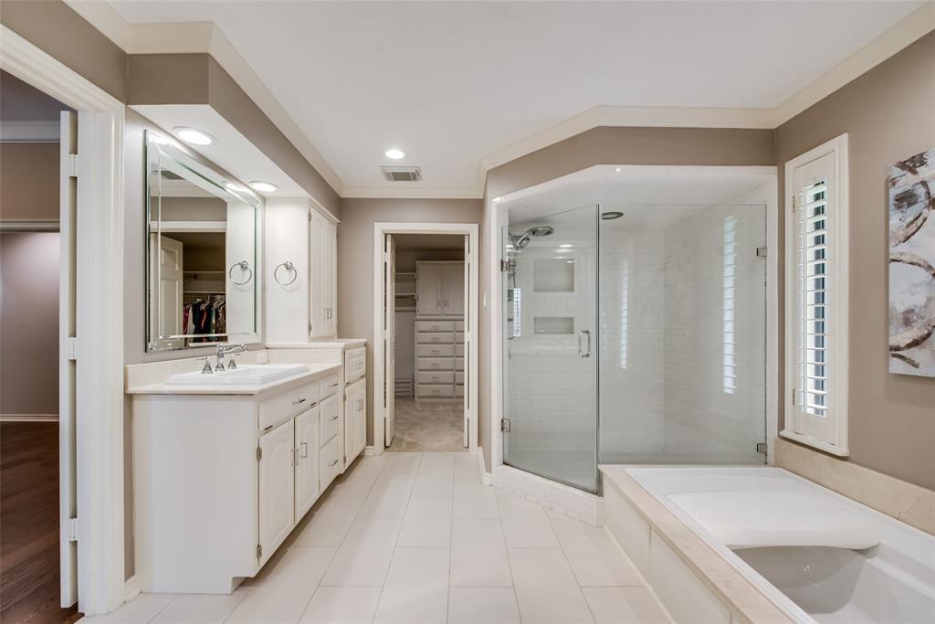 15720 Golden Creek Road Dallas, TX 75248 - Photo 17 of 25 This bathroom features a large glass-enclosed shower, a built-in bathtub, and a vanity with an integrated sink and mirror