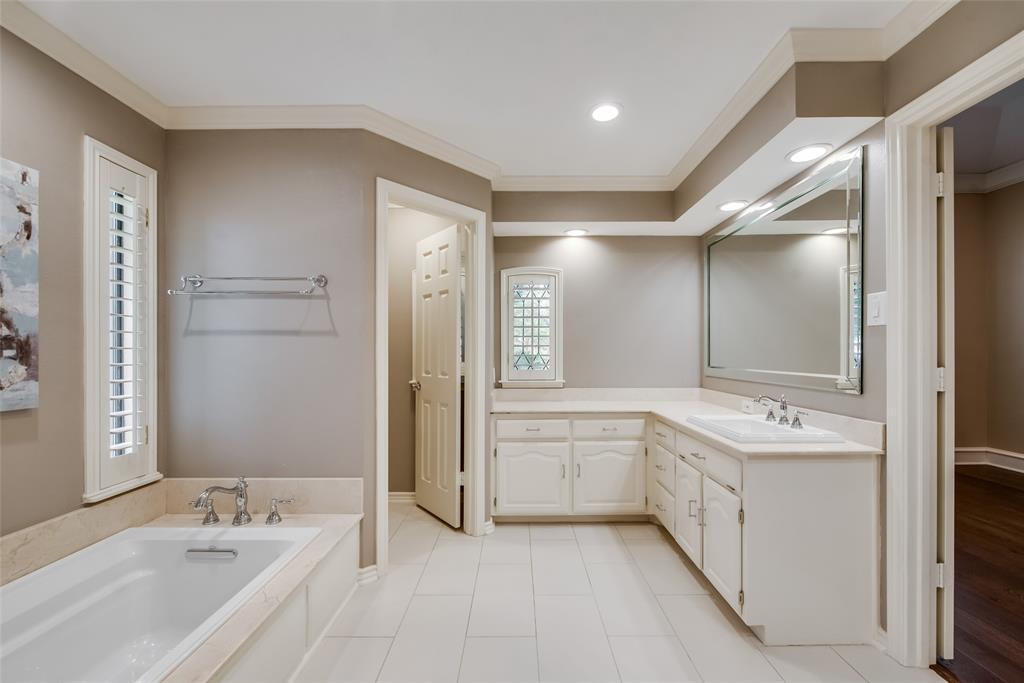 15720 Golden Creek Road Dallas, TX 75248 - Photo 18 of 25 Bathroom featuring a built-in bathtub, a double vanity with two sinks, a large mirror, and recessed lighting