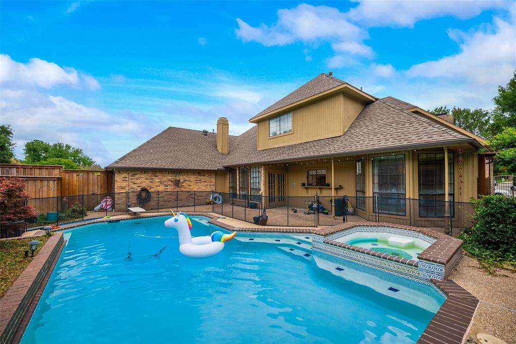 15720 Golden Creek Road Dallas, TX 75248 - Photo 24 of 25 The property features a large backyard with a swimming pool and an integrated hot tub