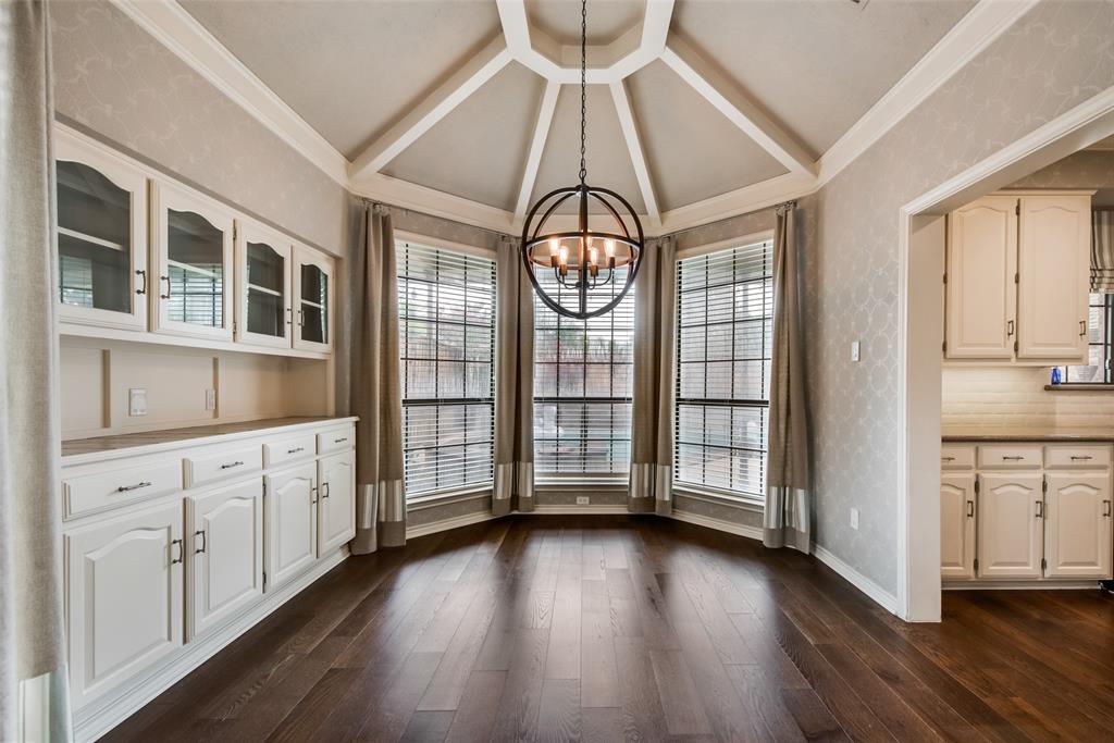 15720 Golden Creek Road Dallas, TX 75248 - Photo 7 of 25 The property features rich hardwood flooring, a unique tray ceiling with a modern spherical chandelier, and a built-in buffet with glass-front upper cabinets and solid lower cabinets