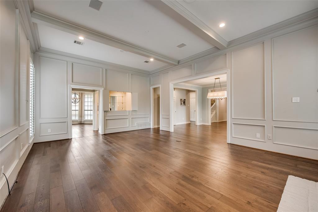 15720 Golden Creek Road Dallas, TX 75248 - Photo 10 of 25 This spacious room features hardwood flooring, elegant wall paneling, and a coffered ceiling with recessed lighting