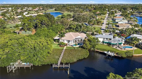 an aerial view of residential houses with outdoor space and lake view