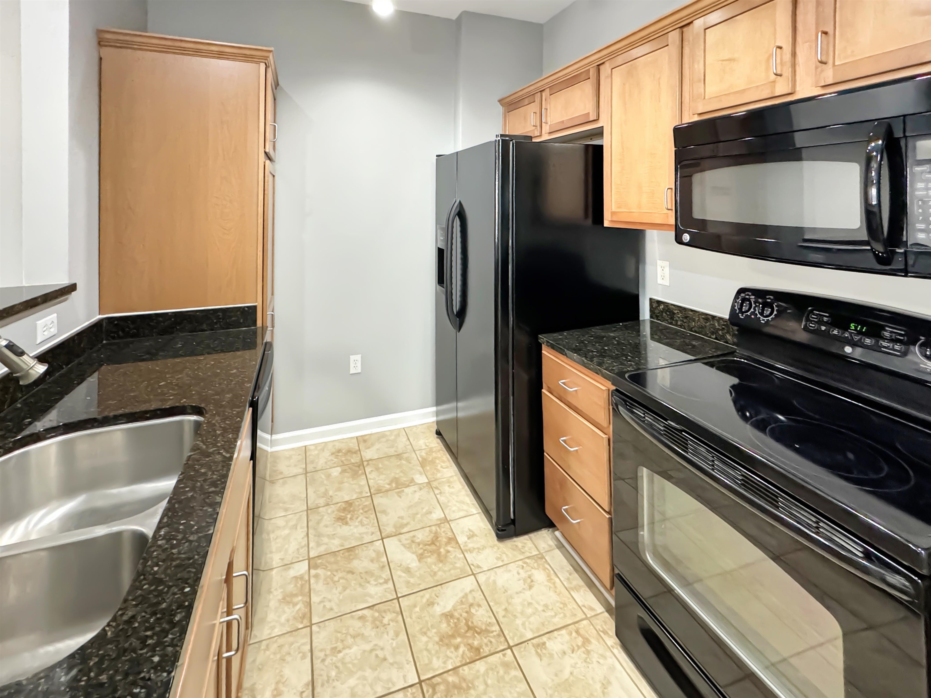 665 Tennessee Street, Unit 306 Memphis, TN 38103 - Photo 14 of 35 a kitchen with granite countertop a refrigerator and a stove