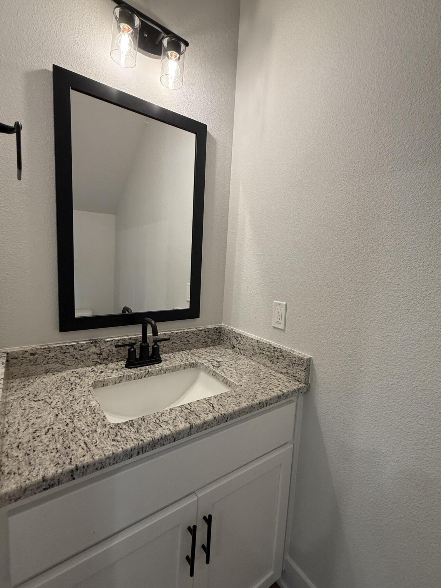 2410 Aleia Lane Crestview, FL 32536 - Photo 27 of 37 a bathroom with a granite countertop sink and mirror