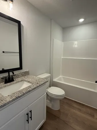 a bathroom with a granite countertop sink toilet and shower