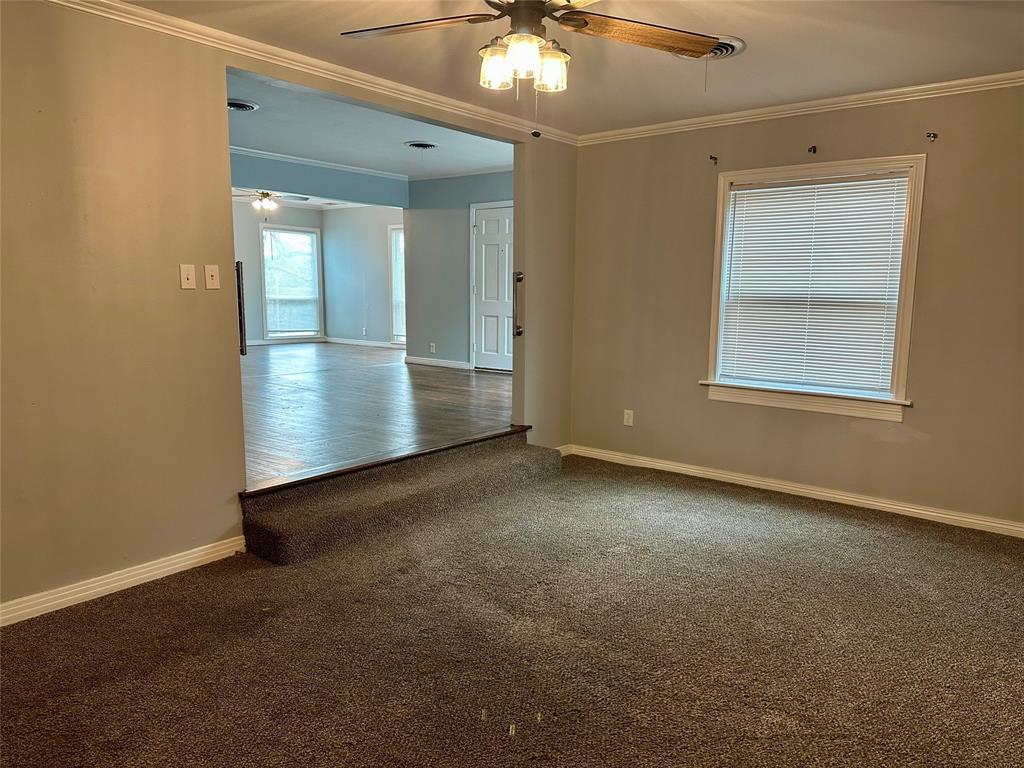 211 Country Club Road Hillsboro, TX 76645 - Photo 6 of 16 an empty room with a chandelier fan and windows