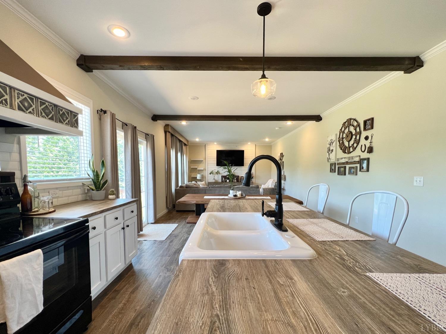2747 Five Forks Road Bedford, VA 24523 - Photo 12 of 40 a large kitchen with stainless steel appliances a large counter top a stove a sink and a chandelier