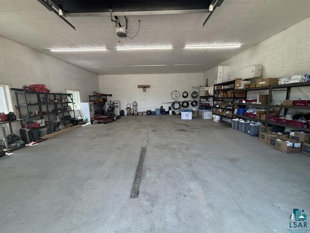 3454 Anderson Road Hibbing, MN 55746 - Photo 28 of 31 Spacious interior garage featuring a concrete floor, high ceilings, and fluorescent lighting