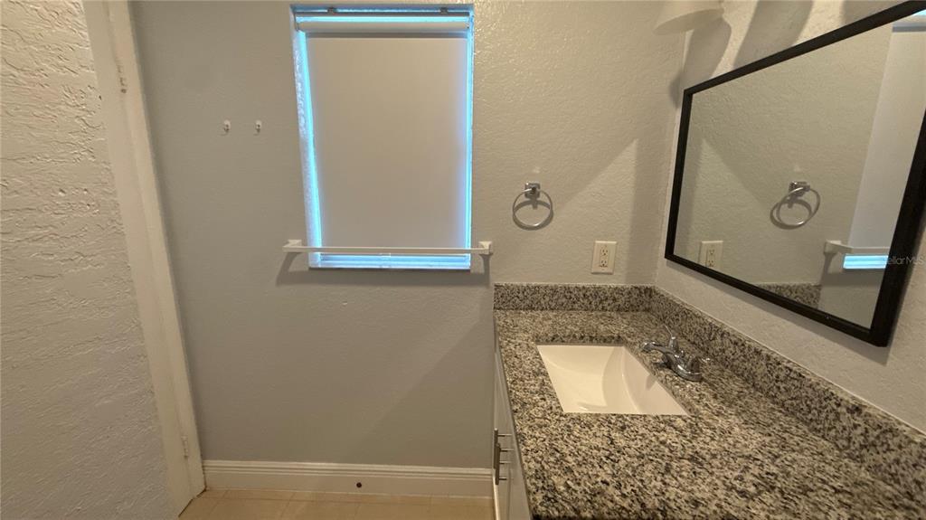 8106 Wichita Way Tampa, FL 33619 - Photo 11 of 21 a bathroom with a shower and mirror