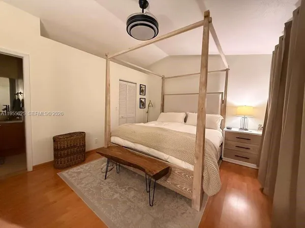 a bedroom with a bed a chandelier and couch