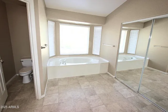 a spacious bathroom with a tub and a toilet