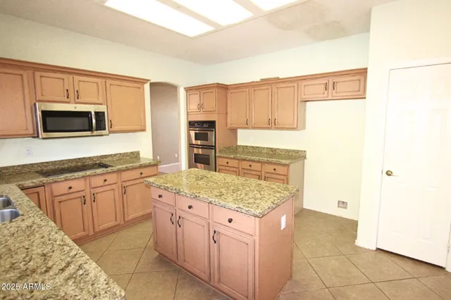 a kitchen with stainless steel appliances granite countertop a sink stove and microwave