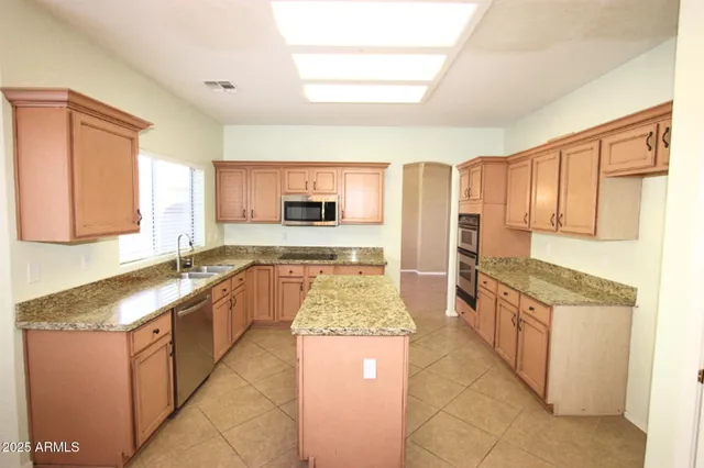 a large kitchen with granite countertop a sink and a stove