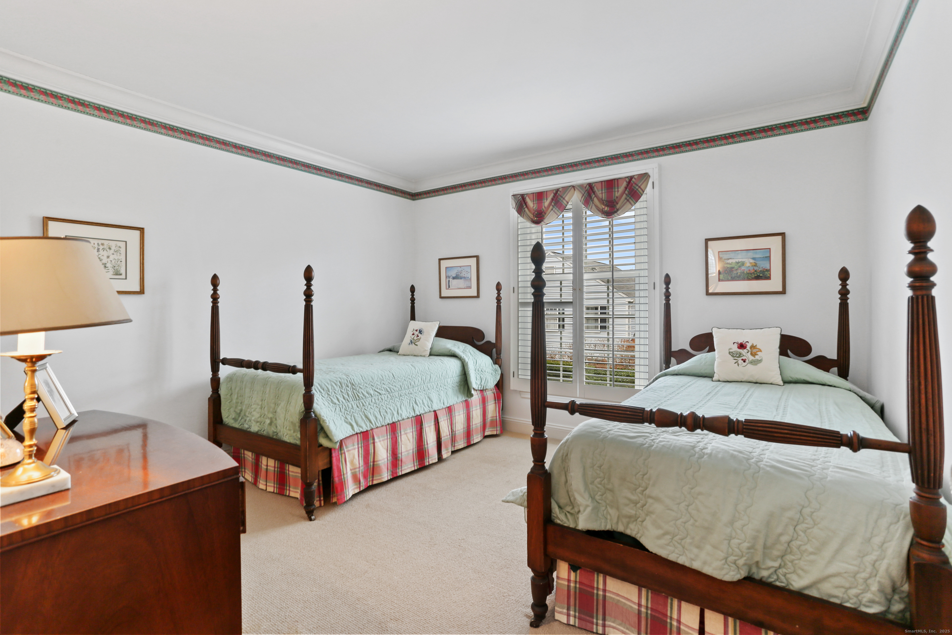 47 Bank Street, Unit 47 New Canaan, CT 06840 - Photo 33 of 40 a bedroom with a bed a dresser next to a window