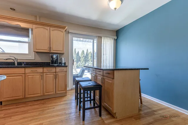 a kitchen with granite countertop a sink cabinets and wooden floor