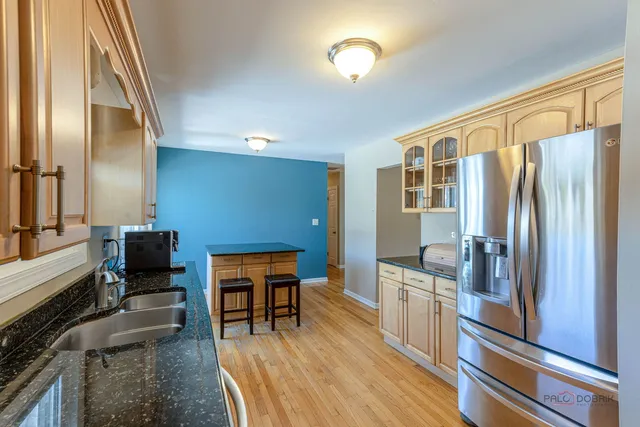 a kitchen with stainless steel appliances granite countertop a refrigerator and a stove top oven